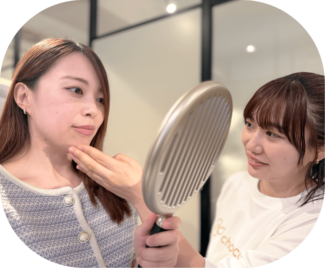 手鏡を見るお客様の顔に触れながら対応するスタッフ