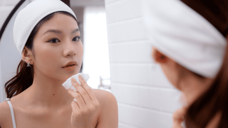 鏡を見て顔を確認している女性