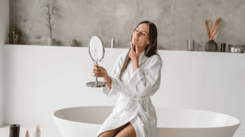 鏡で顔をチェックする女性
