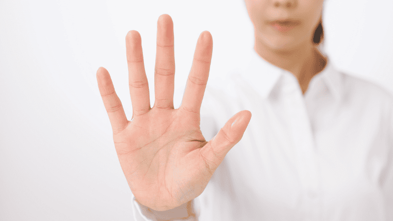 手のひらを出し注意喚起する女性