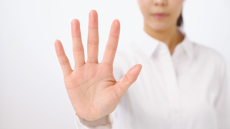 手でストップする女性