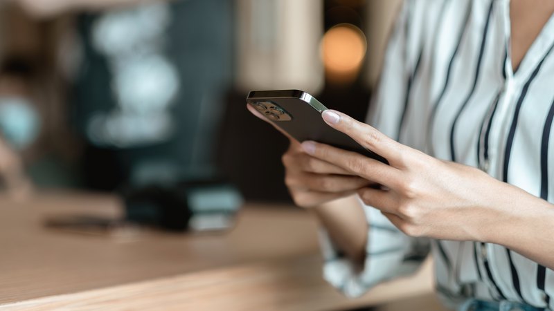 スマートフォンで予約を入れる女性の手元